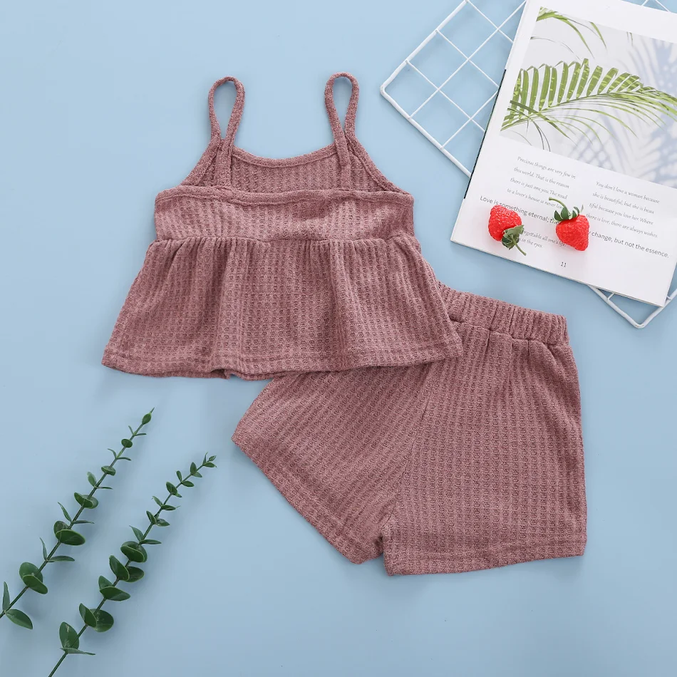 Conjunto de duas peças sem mangas com suspensórios e shorts em cor sólida. Ideal para um visual leve e fresco, perfeito para o verão.