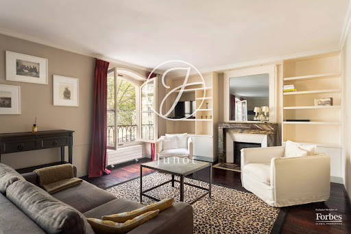 Living room with grey sofa and white armchairs in this luxury property for sale in Paris 7ème ($1,401,345 - 65 m²)