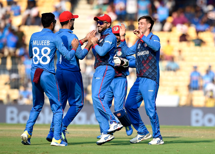 Afghanistan's Noor Ahmad celebrates the wicket of Pakistan's Mohammad Rizwan with teammates.