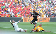 Luvuyo Memela of Orlando Pirates scoring his goal past Itumeleng Khune and Siyabonga Ngezana of Kaizer Chiefs during the Absa Premiership match between at FNB Stadium on March 03, 2018.