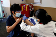 A medical worker receives a dose of the coronavirus disease (Covid-19) vaccine as Japan launches its inoculation campaign, at Tokyo Medical Center in Tokyo, Japan February 17, 2021.