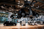 Workers assemble an e-Golf electric car at the new production line of the Transparent Factory of German carmaker Volkswagen in Dresden, Germany March 30, 2017. 