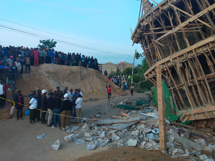 People watch from a distance from the collapsed building in Murang'a, June 19, 2023.