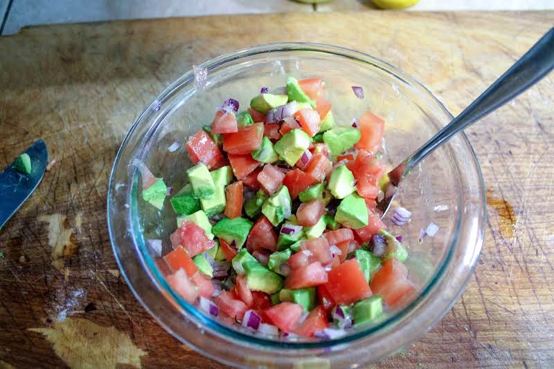 Chopped Tomatoes, Onion, Avocado, Lime Juice, And Salt In A Bowl.