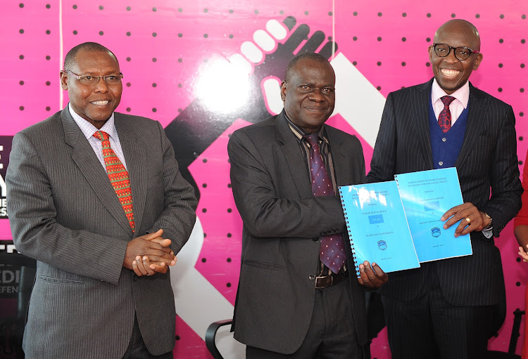 MKU quality assurance director Peter Wanderi looks on as MKU vice chancellor Stanley Waudo and Telkom MD Kris Senanu exchange documents after signing an MoU to enhance digital learning