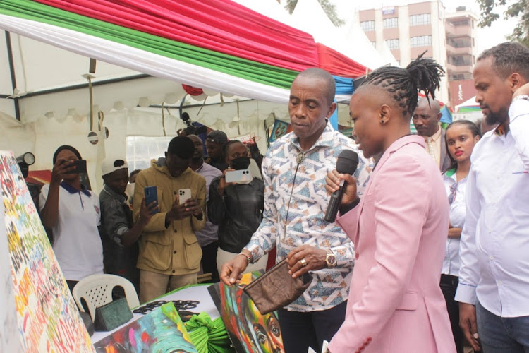 Governor Kimani Wamatangi is shown an innovation by a young person during the International Youth Day celebrations