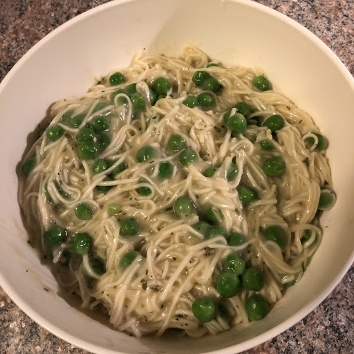 Bowl of garlic butter ramen with peas.