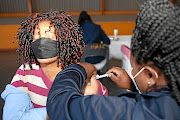 A woman receives the Covid-19 vaccine at a Meadowlands vaccination site in Soweto on Wednesday after the health department opened vaccine registration (vaccine.enroll.health.gov.za/) to people aged 35 years and above. 