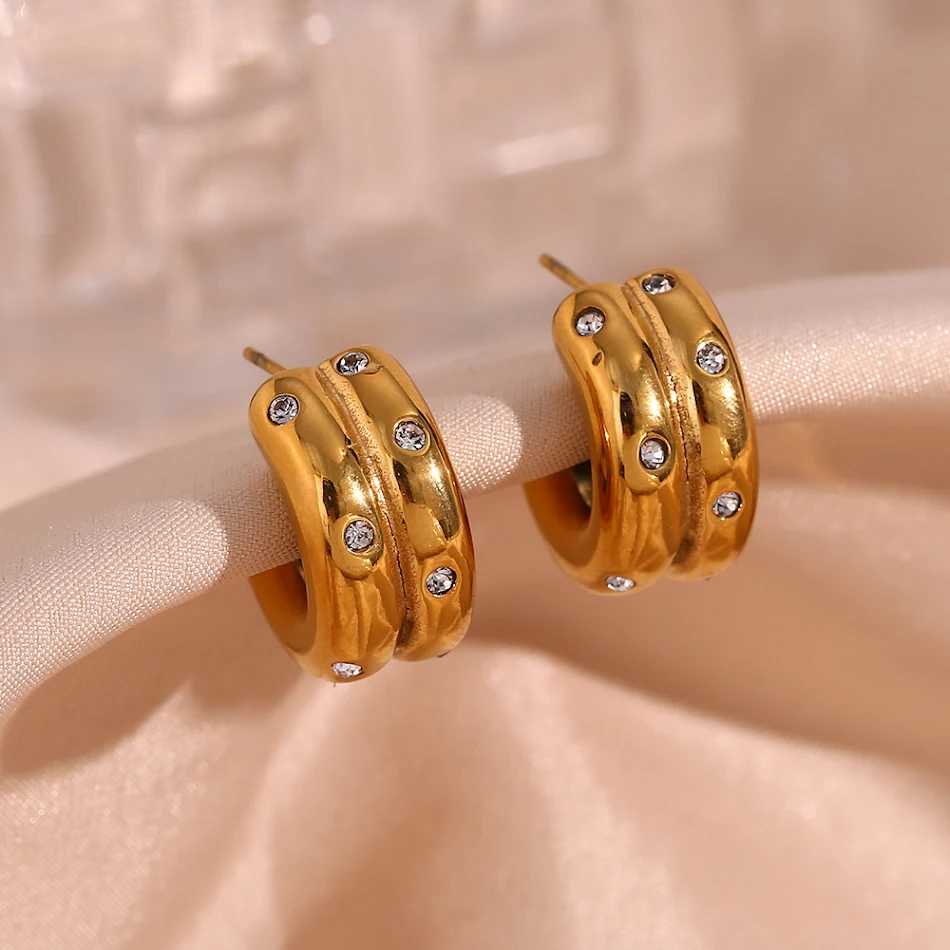 Roestvrijstalen oorbellen met dikke verticale nerf, dubbele C-vorm en strass. Elegantie en glamour voor een verbluffende uitstraling.