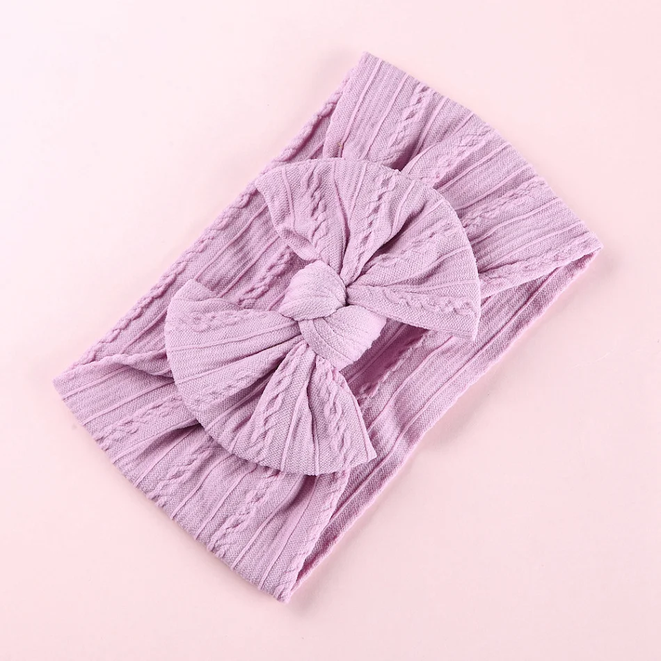 Bandeau élastique bébé avec nœud jacquard et bord large en nylon. Doux, extensible et idéal pour les nouveau-nés et bébés.