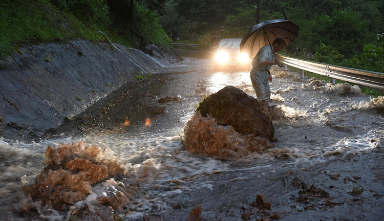 A flooded road with fallen rocks is pictured in Hita in Oita Prefecture, Japan, after torrential rain hits, in this photo taken by Kyodo on July 5, 2017.