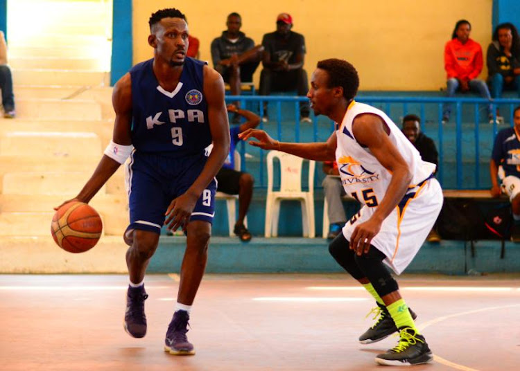 KPA's KPA's Victor Odendo (L) charges against Steve Kago of KCA during their KBF league match at Nyayo Gymnasium on July