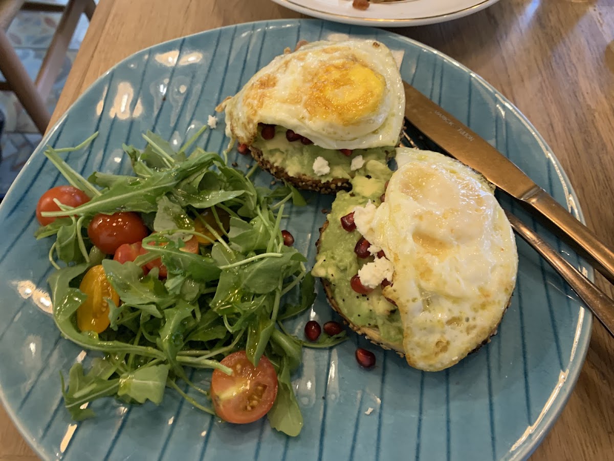 Superseed bagel with avocado, pomegrante seeds, and egg