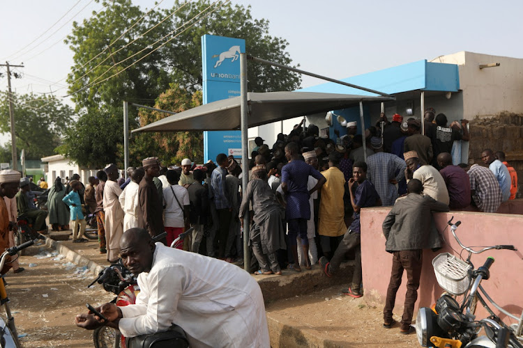 People queue to withdraw cash from an ATM ahead of presidential elections in Nigeria.
