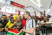 Bafana Bafana coach Stuart Baxter interacts with the supporters during at OR Tambo International Airport. 