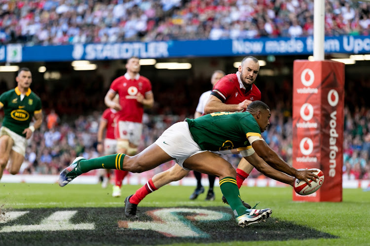 Damian Willemse runs in another try despite the vain attempt of Cai Evans to stop him in the Springboks' 52-16 win over Wales in Cardiff on Saturday.