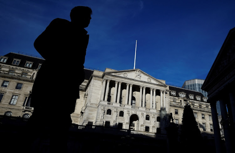 A man is silhouetted as he walks past the Bank of England in the City of London, Britain. Picture: REUTERS/CLODAGH KILCOYNE