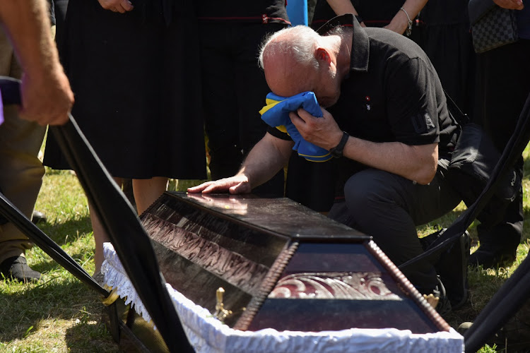 A relative reacts near a coffin with the body of Ukrainian serviceman Mykola Zabavchuk, who was recently killed in a battle against Russian troops, as Russia's attack on Ukraine continues, during a funeral ceremony in Lviv, Ukraine on July 26, 2022.