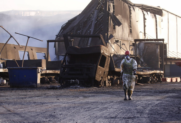 A member of a hazardous waste clean-up crew at a warehouse targeted during looting in Durban in July. File photo.