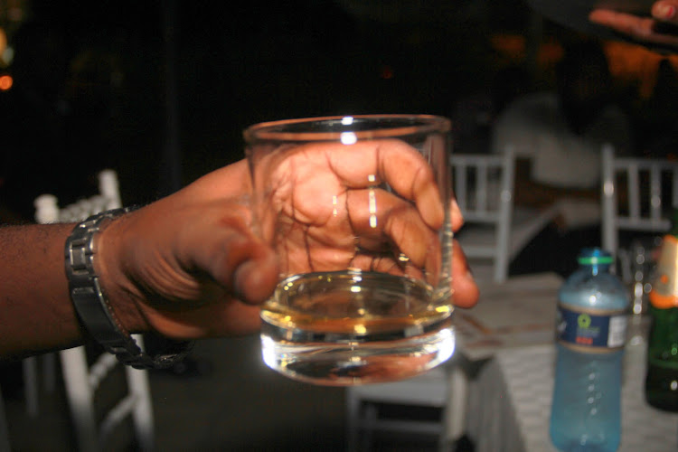 A patron with a glass of alcohol on display.