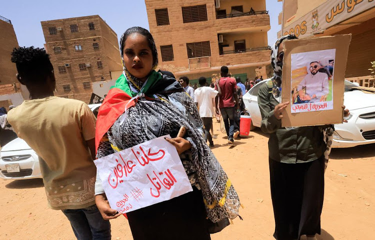 Demonstrators who have gathered outside the court carry a picture of their colleague during the procedural session of the trial of demonstrators accused of killing a police brigadier, in Khartoum, Sudan May 29, 2022.