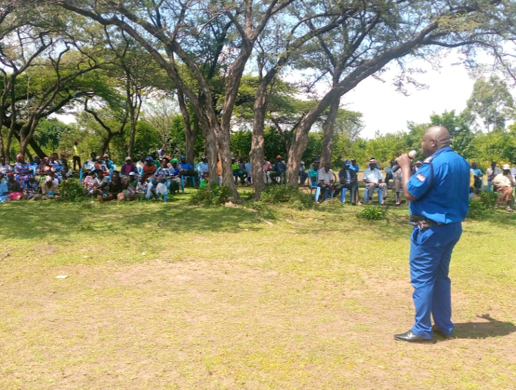 Police officer addressing the crowd during the security and development baraza convened by East Kano Development Agency at Wang'neno trading centre, Nyando Sub-County.