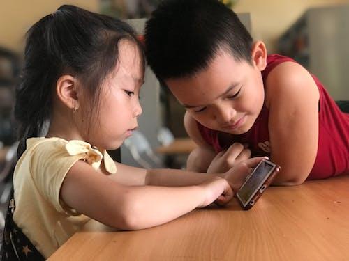 Free Children Watching on a Cellphone Stock Photo