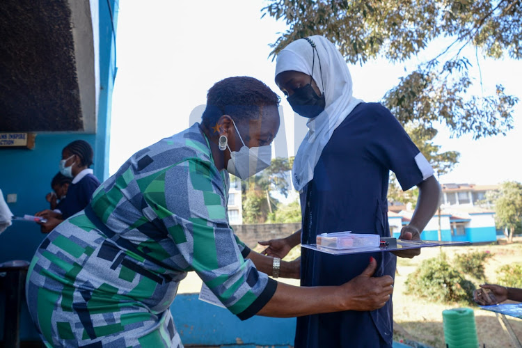 An invigilator frisks students of St. Georges Primary School on March 7, 2022 during the kick-off of the KCPE 2021 examinations.