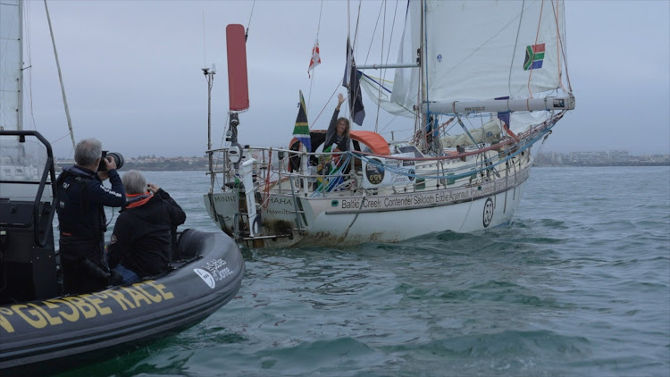 SA’s Kirsten Neuschafer waves after crossing the finish line of the 2022 Golden Globe Race off Les Sables d’Olonne, in France