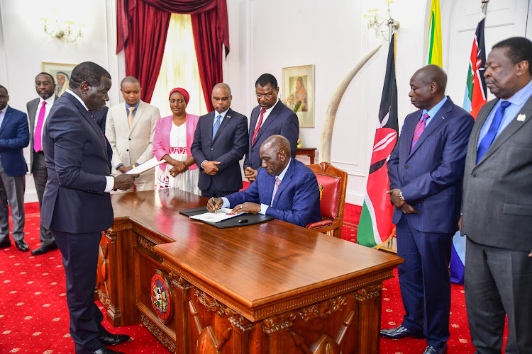 President William Ruto assenting to the Finance Bill, 2023 as leaders witness at State House on June 26, 2023