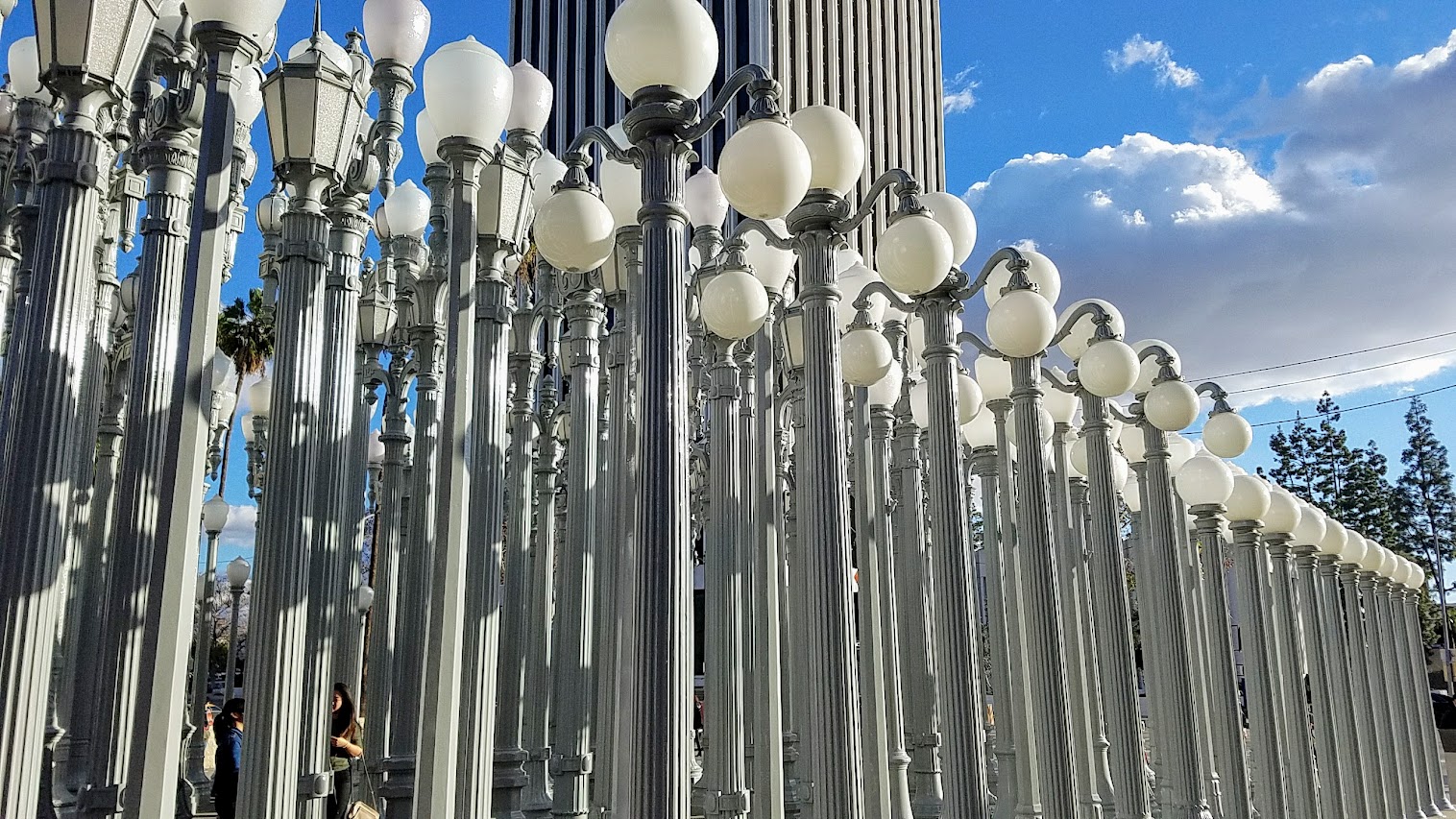 One of the most famous and free (since it is an outdoor sculpture) art you can see in the park at LACMA is the iconic Urban Lights. Created by Chris Burden, it is made of 202 restored street lamps in various styles based on where they were from (most are from southern California and some from Portland Oregon too!). The lamps are painted grey and assembled in a grid, and are solar powered and become lit in the evening.