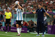 Marcos Acuna of Argentina prepares for a throw-in while coach Lionel Scaloni looks on in the World Cup Group C match against Mexico at Lusail Stadium on November 26 2022.