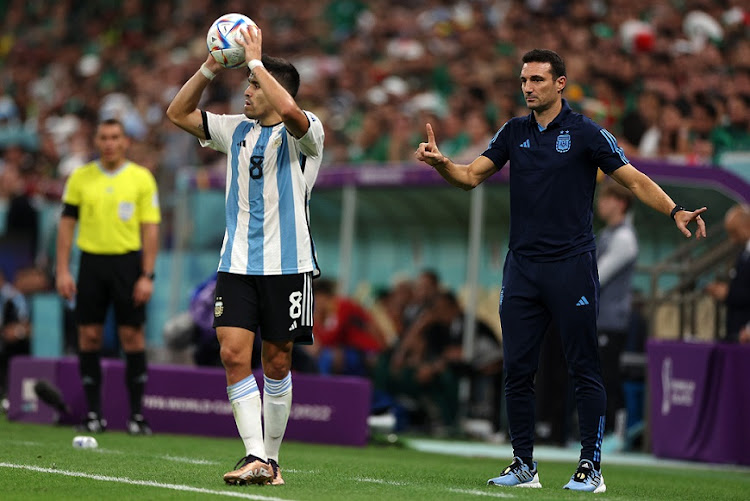 Marcos Acuna of Argentina prepares for a throw-in while coach Lionel Scaloni looks on in the World Cup Group C match against Mexico at Lusail Stadium on November 26 2022.