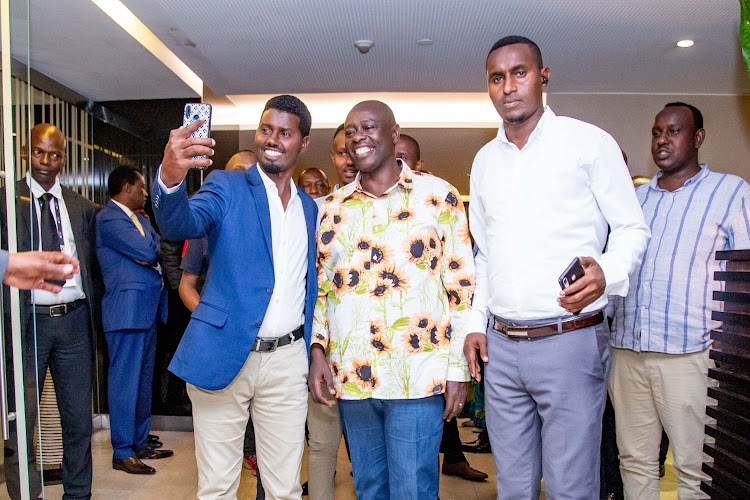 Deputy President Rigathi Gachagua take a selfie with a Kenyan living in Angola on Thursday, December 9, 2022.