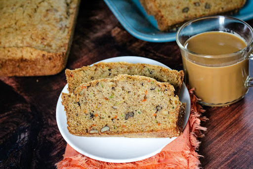 Two slices of Zucchini Carrot Bread with a cup of coffee.