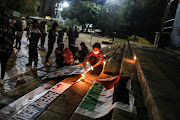 Students and residents take part in a night vigil, 18 May 2021, at the University of Witwatersrand in Johannesburg, for a solidarity picket organised by the Wits Palestine Solidarity Committee, over the occupation and conflict that’s unfolding in Palestine.  