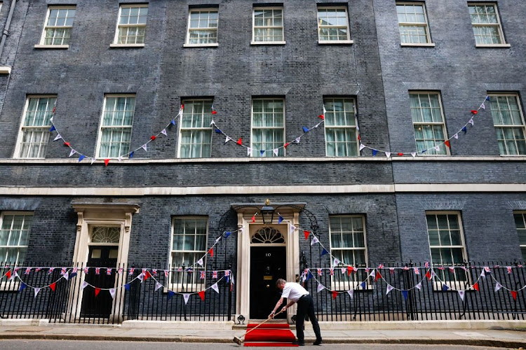 A worker sweeps a red carpet ahead of the arrival of Sheikh Tamim bin Hamad Al Thani, Emir of Qatar, at 10 Downing Street in London, UK, on May 5, 2023. Sunak's UK Conservatives lost scores of local council seats in a bruising first election for the prime minister that suggests the ruling party is in danger of losing power in a national vote that’s expected next year. Picture: CARLOS JASSO/BLOOMBERG