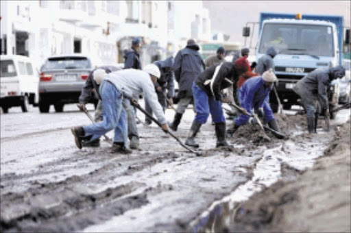 A municipal workers clean up the mud in Victoria road in Camps Bay after the storm cause havoc in Cape Town.Picture: ESA ALEXANDER 13/07/2009