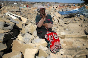 Liza Modiba sits among the rubble of her and other residents' homes next to the Malboro Gautrain station, that were demolished by the Red Ants in Alexandra. The writer says the lives of the poor do not matter in this so-called democratic SA.