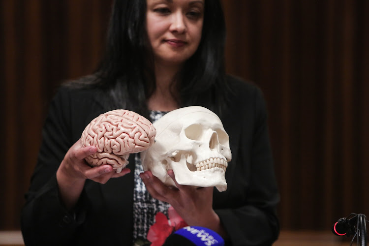 Forensic Pathologist, Dr Shakeera Holland, shows off a skull during the inquest into the death of Ahmed Timol at the North Gauteng High court in Pretoria. Holland's findings suggest that Timol had suffered serious injuries prior to the fall from the 10th floor of John Foster Square in Johannesburg on 1971.