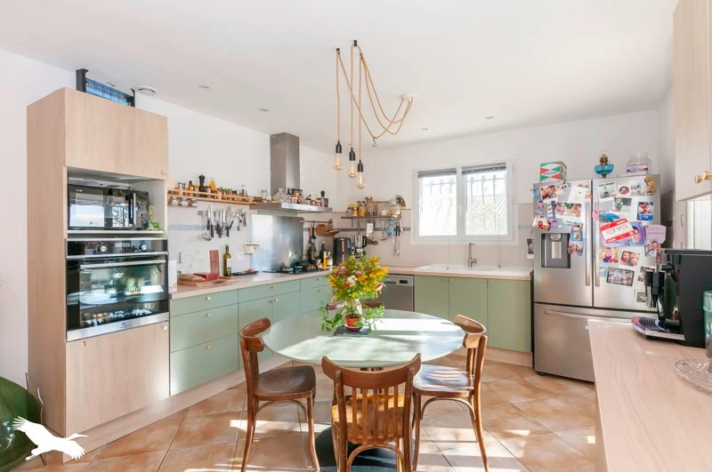 Cuisine avec table ronde et éléments verts - Maison à vendre à POMEROLS, 5 pièces, 4 chambres