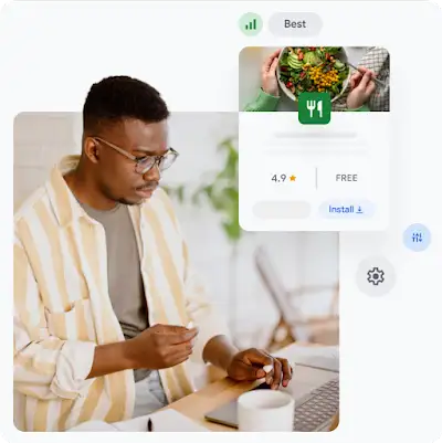 A man, wearing glasses and striped white and yellow shirt, works on a laptop; a food delivery app screen floats to the right