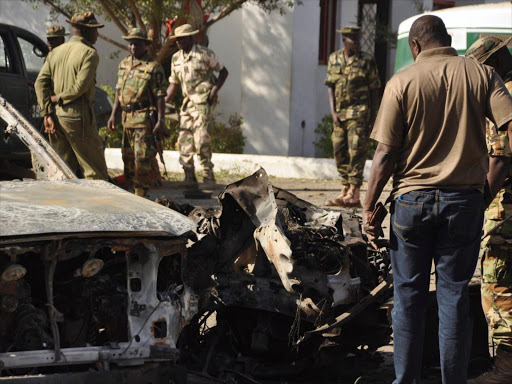 A file photo of bomb experts and military personnel investigating the site of an explosion at a police station in Kano, Nigeria November 15, 2014. /REUTERS