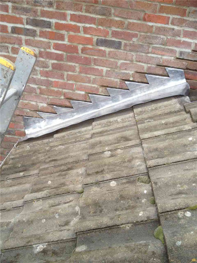 Lead flashing in process of being fitted into wall.