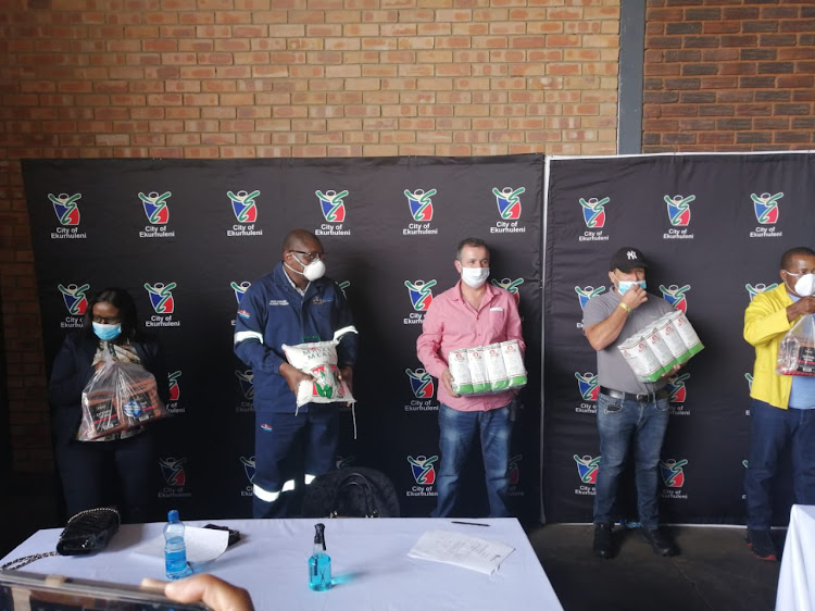 Gauteng premier David Makhura (in blue overalls) at the opening of the Springs food bank in Ekurhuleni on Tuesday where he said casual, or piece, workers were 'falling by the wayside'.