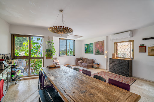 Living dining room with large wooden table in this luxury property for sale in Tel Aviv-Yafo ($2,451,955 - 120 m²)