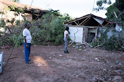 Michael Govindasamy, 56, and his daughter Silicia Govindasamy, 24, examin the destruction caused by a mudslide on Tuesday night that struck his house in Springfield, Durban.