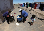 Melvina Adams and Michelle Fink of Hillside do their washing in a bucket in Beaufort West on November 08, 2017.