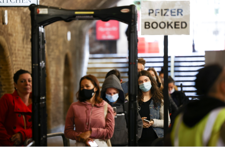 People queue to receive a dose of the Pfizer BioNTech vaccine at an NHS vaccination centre hosted at the Heaven nightclub, amid the coronavirus disease pandemic, in London, Britain, on August 8 2021.