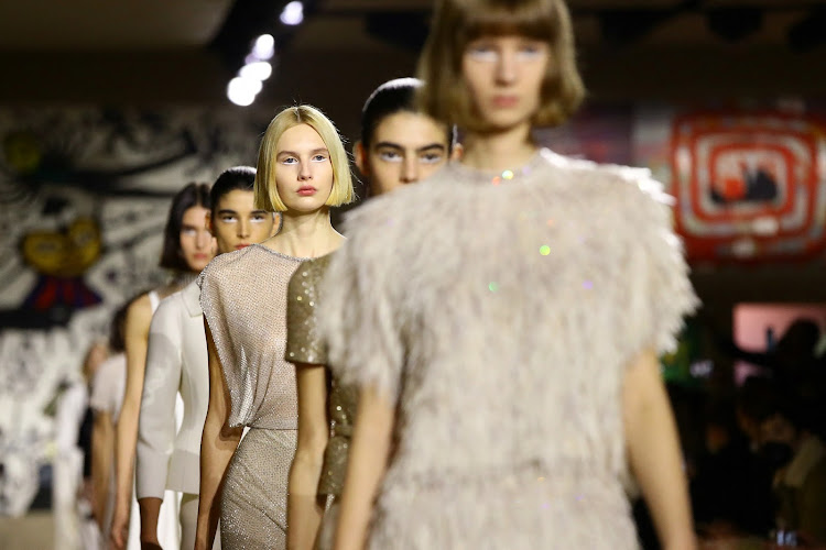 Models present creations by designer Maria Grazia Chiuri as part of her Haute Couture Spring-Summer 2022 collection show for fashion house Dior in Paris.